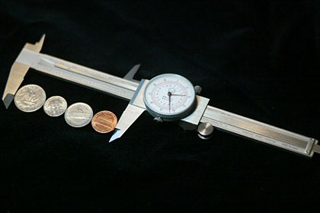 Photograph of coins in a caliper.